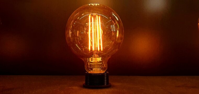 Decorative LED incandescent light bulb close-up. Modern rope chandelier. Vintage and retro lamp bulb. Filament LED lamp. Modern night light. Decorative flickering LED lighting.