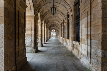 Arcades with stone arches in the buildings of the Plaza del Obradoiro in Santiago de Compostela, Spain.
