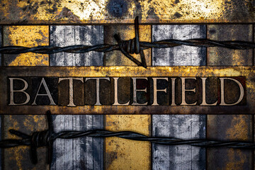 Battlefield text with barbed wire in real authentic typeset letters on vintage textured silver grunge copper and gold background
