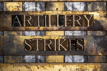 Artillery Strikes text in real authentic typeset letters on vintage textured silver grunge copper and gold background