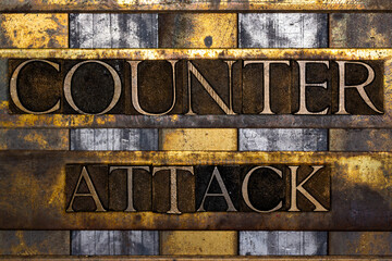 Counter Attack text in real authentic typeset letters on vintage textured silver grunge copper and gold background