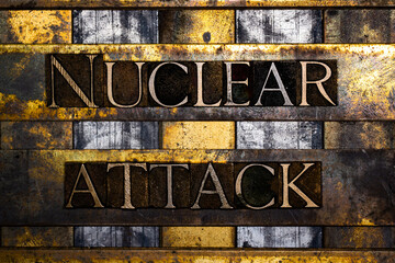 Nuclear Attack text in real authentic typeset letters on vintage textured silver grunge copper and gold background