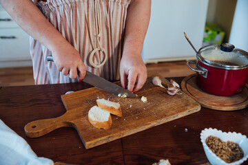 Woman Cook Housewife Cuts Bread With Knife For Cooking