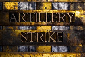 Artillery Strike text in real authentic typeset letters on vintage textured silver grunge copper and gold background