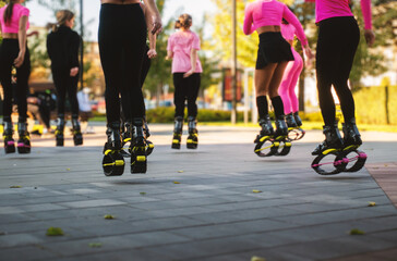 A group of girls are jumping on the street in a city park.