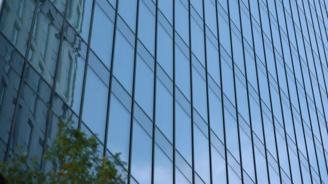 Close-up high rise skyscraper glass facade windows grid dolly shot, financial district looking up modern architecture office buildings detail, city business downtown gimbal moving camera glide
