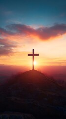 Fototapeta premium A cross atop the hill with a beautiful sunrise in the background, an Easter-themed background with copy space for text