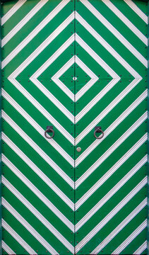Symmetrical green and white patterned door with metal accents
