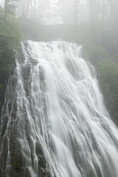 Misty Narada waterfall flowing through a lush forest