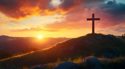 Fototapeta premium A cross atop the hill with a beautiful sunrise in the background, an Easter-themed background with copy space for text