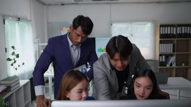 Tension fills the office as two managers criticize the work of two employees at a desktop computer. Demanding voices create an atmosphere of stress and conflict in the workplace