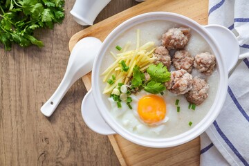 Congee or rice porridge with pork and eggs,in white ceramic bowl , thai food, asian food, chinese food