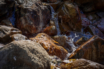 Close-up of water trickling over a rock cascade, with splashes capturing the essence of nature’s...