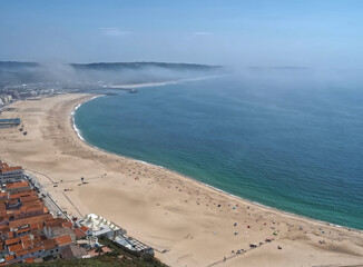 Nazare in central Portugal with an epic view of the city and the Atlantic ocean with beach from the viewpoint named Miradouro do Suberco