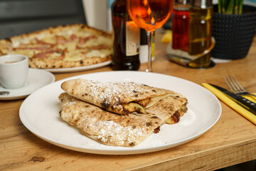 Italian dessert - calzone filled with chocolate, banana and powdered sugar at a restaurant