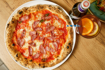 Original Italian pizza with ham, tomato sauce and cheese at a restaurant