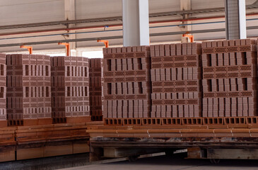 A pile of bricks stacked on pallets in a warehouse