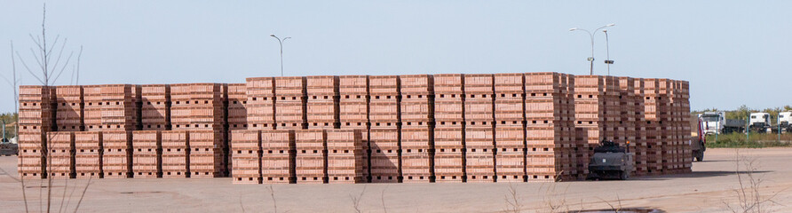 A large pile of wooden crates sits in a parking lot