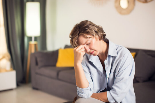 Sinus ache causing very paintful headache. Unhealthy woman feeling pain. Sharp strong sore. Sinus pain, sinus pressure, sinusitis. Sad woman holding her head because sinus pain