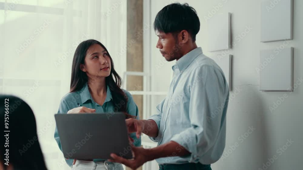 Poster businessman and businesswoman are having a work discussion. they are using a laptop and appear to be