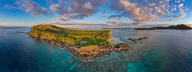 Beautiful sunrise above tropical Island coconut palm trees on remote island in the Pacific Ocean