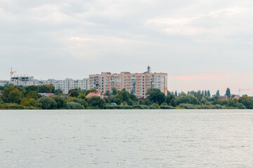 Fototapeta premium overcast third world developed country USSR panel architecture living panel apartment building on river waterfront abandoned wasteland country side outskirts settlement town scape rainy cloudy view