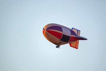 A colorful airship flies in the blue sky.