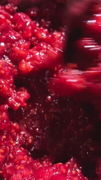 Close up of fresh, mashed, frozen, raspberry in metal container. mash raspberries