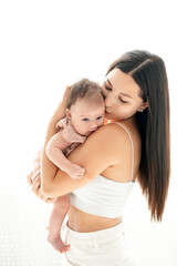 a mother with a newborn baby, a young mother holding a small newborn baby in her arms, gently hugging and kissing him, a space for text on a white isolated background, happy motherhood