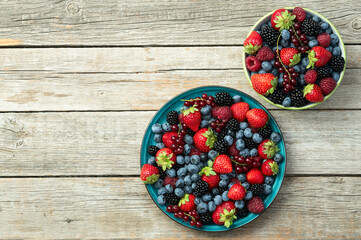 Mix of ripe colorful berries in bowl photography . Blueberry , strawberry , raspberry , blackberry...