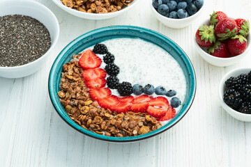 Healthy breakfast . Yogurt with berries ( strawberry , raspberry , blueberry , blackberry ) , granola and chia seeds . Top view