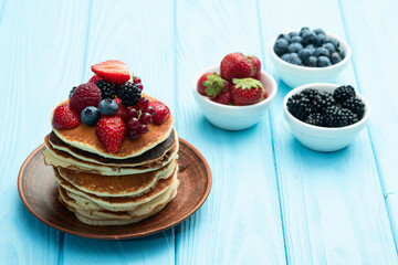 Stack of homemade american pancakes with berries . Top view