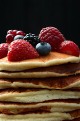 Stack of homemade american pancakes with berries . Top view