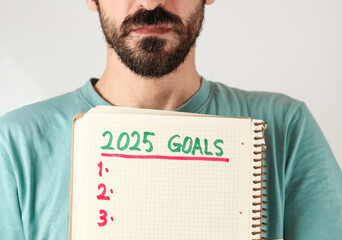 A handsome caucasian men show his goals for 2025 years. Three goals for new year. Isolated on white.
