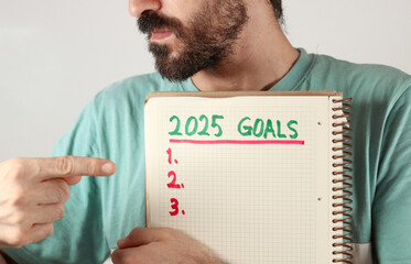 A handsome caucasian men show his goals for 2025 years. Three goals for new year. Isolated on white.