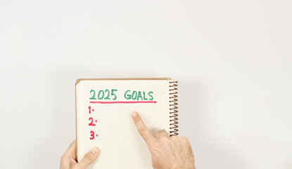 A  caucasian men showing his first goal for 2025 years. Three goals for new year. Top view, isolated on white.