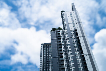 Fototapeta premium Skyscraper with blue sky background with white clouds floating blur, in the city on a clear summer day