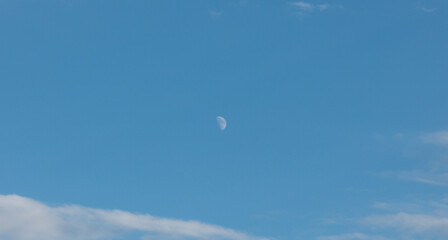 The moon appears in the daytime sky