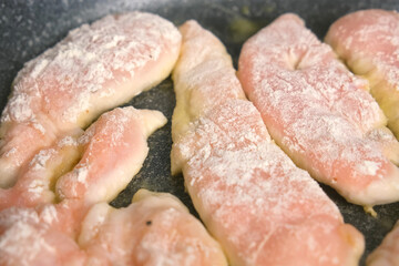 Cooking frying breading chicken breast meat in flour on skillet at home on kitchen at home. Ingredient recipe cuisine culinary. Homemade meal preparation. Protein meat healthy dish.