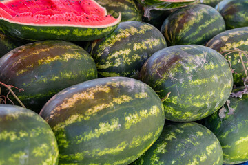 Freshly cut watermelon on display at a summer farmers market in bright sunlight