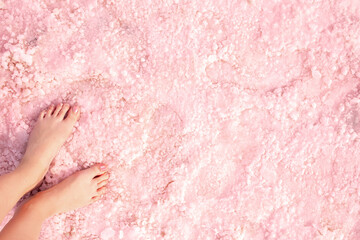 Pink lake. Girl's feet on water with pink salt. A unique rare natural phenomenon. Salt Lake.