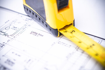 Close-up of a Tape Measure on Architectural Blueprints in a Construction Environment