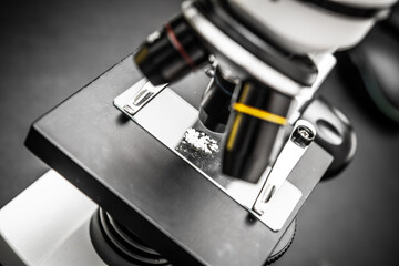 Close-up of Microscope Objective Lenses Focusing on a Slide with Specimen for Research and Analysis in Laboratory Environment