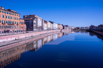 Obraz premium Pisa's iconic blend of history and art, reflected in the gentle flow of the Arno river