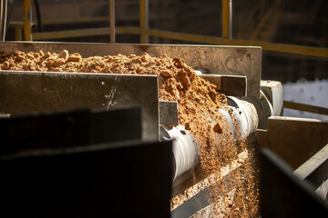 Cement factory. A conveyor with stones and gravel undergoes the crushing process. Modern...