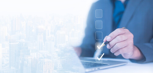 Businessman checklist concept as clipboard document checklist form on the virtual screen Use your hands or a pen to check the correct control gaps and check the quality standards of the work.