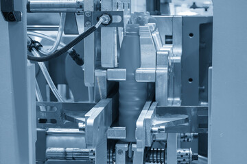 The blow mold machine operation in the light blue scene.