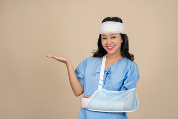 Asian female patient wearing soft cast due to arm injury and head injury. Personal accident and insurance concept.