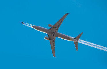 Trail of white smoke from the airplane on blue sky, airplane heavy traffic in the sky