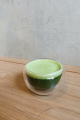 close up of Japanese hot green tea in a glass on a wooden table